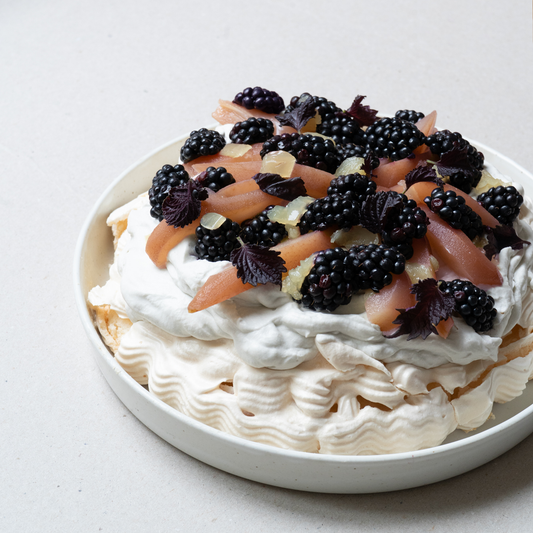 Pavlova con moras, peras, nata y sésamo negro